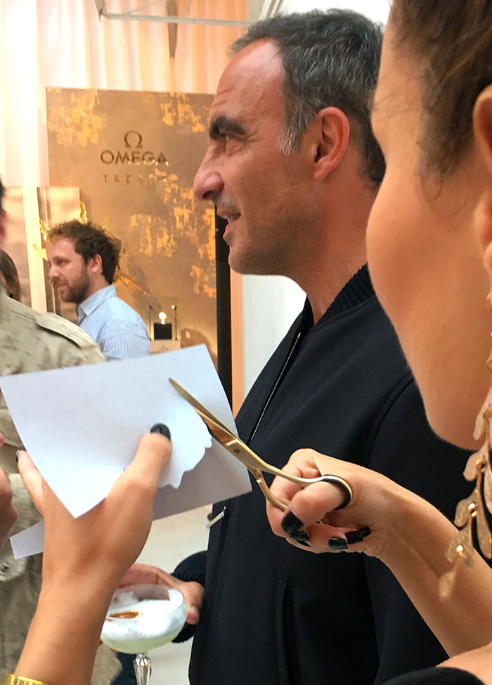 Silhouettiste découpant une silhouette aux ciseaux lors d'un événement pour la maison Omega