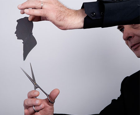 Silhouettiste découpant une silhouette aux ciseaux, savoir-faire transmis depuis 1960